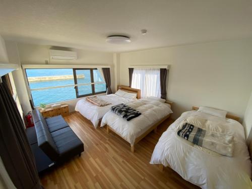 two beds in a room with a view of the ocean at Tiz wan 明石大橋 in Awaji