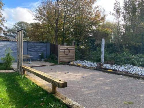 einen Garten mit einer Holzbank und einem Zaun in der Unterkunft Le clos marin in Blendecques