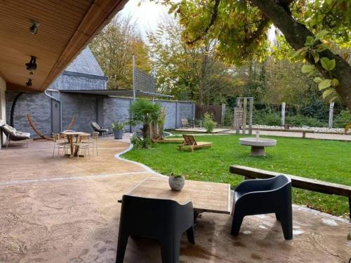 eine Terrasse mit einem Tisch und Stühlen im Hof in der Unterkunft Le clos marin in Blendecques