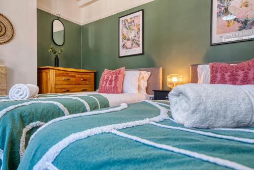 two beds in a room with green walls at Brewery Loft - 3 Bedroom Bright Spacious apartment in the centre of town, Wifi, Netflix in Cirencester