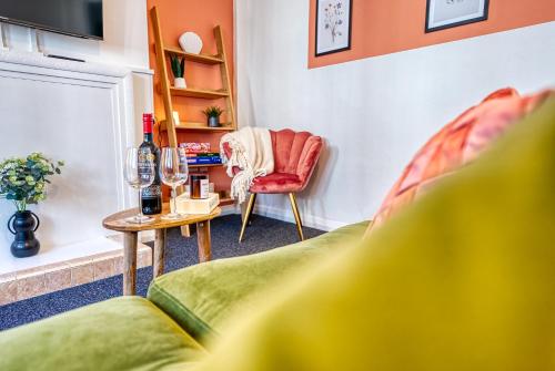 a living room with a green couch and a table at Brewery Loft - 3 Bedroom Bright Spacious apartment in the centre of town, Wifi, Netflix in Cirencester