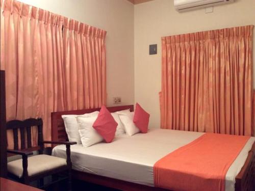 1 dormitorio con cama, silla y cortinas en Veda Wellness B&B and Yoga Centre, en Kochi