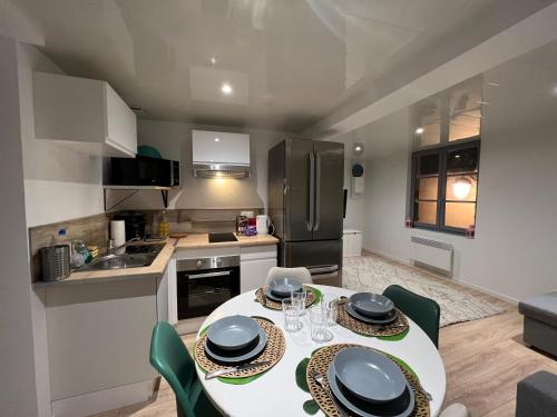 une cuisine et une salle à manger avec une table et des chaises dans l'établissement Le cocon du centre ville, à Saint-Dizier