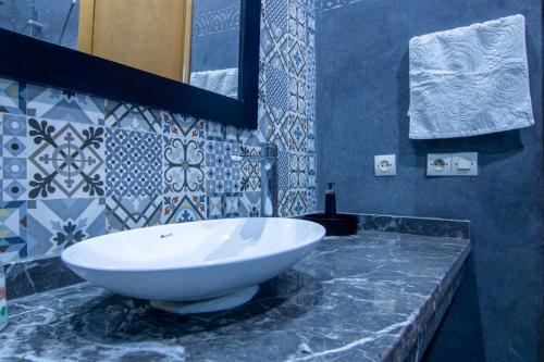 La salle de bains est pourvue d'un lavabo blanc sur un comptoir en marbre. dans l'établissement La ferme, à Marrakech