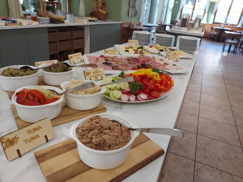 a table with many bowls of food on it at Pohorje Village Wellbeing Resort - Forest Hotel Videc in Pohorje