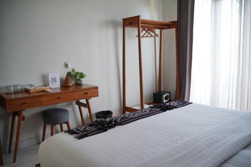 a bedroom with a desk and a bed and a table and chair at Escape Bajo in Labuan Bajo