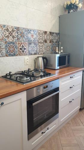 uma cozinha com um fogão e um micro-ondas em 1-комнатная квартира em Kokshetau