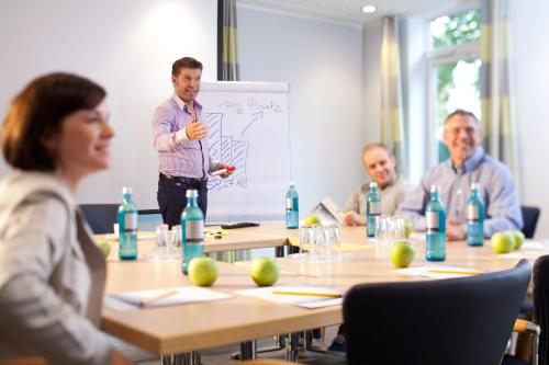 a man giving a presentation in a meeting room at Hotel Bakenhof in Münster