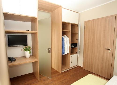 a room with a closet with a television and a door at Hotel Bakenhof in Münster