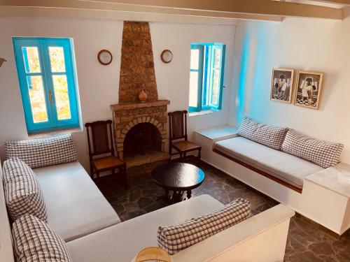 uma sala de estar com um sofá e uma lareira em Peloponnese Hideout - Traditional stone house em Akrata