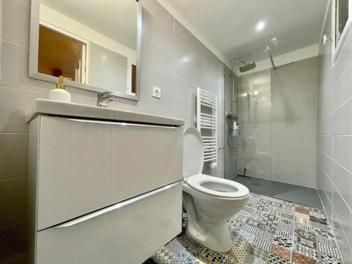 une salle de bain blanche avec toilettes et douche dans l'établissement Appartement confort - Carcassonne centre, à Carcassonne