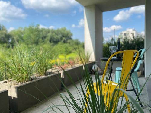 a yellow chair sitting on a balcony with plants at Smart Art :) z bezpłatnym parkingiem podziemnym in Kielce
