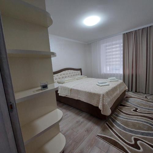 a bedroom with a bed and a book shelf at Apartament lux new in Chişinău