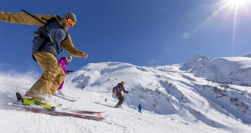 a group of people skiing down a snow covered mountain at Appartement Velaer Valmorel in Valmorel