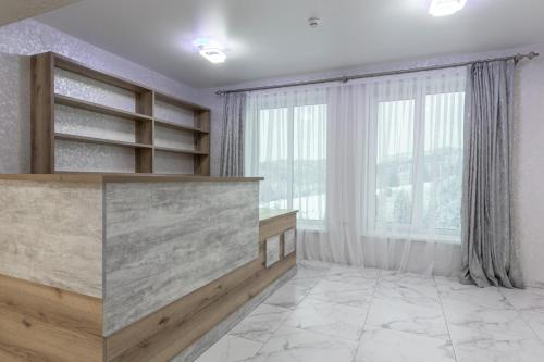 a large room with white walls and a large window at Шепіт Лісу in Bukovel