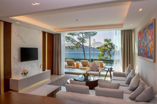 a living room with a couch and a tv at Vogue Hotel Supreme Bodrum in Torba