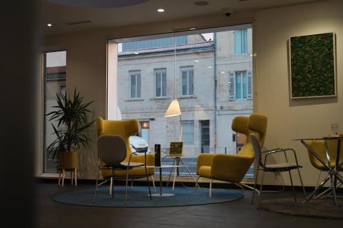 a waiting room with chairs and a large window at Seeko'o Hotel Bordeaux in Bordeaux