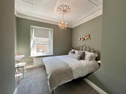 a bedroom with a bed and a chandelier at 20 Lisburn Street in Alnwick