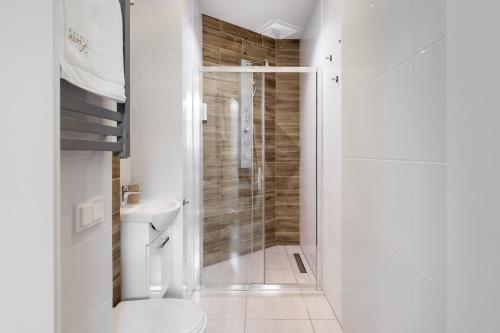 biała łazienka z prysznicem i toaletą w obiekcie Luxe Living Castle View w Krakowie