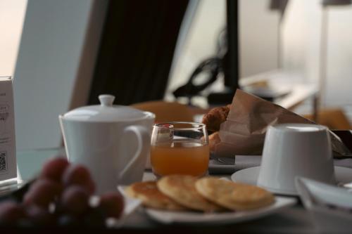 a table with a plate of food and a glass of orange juice at Seeko'o Hotel Bordeaux in Bordeaux
