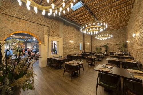 un restaurante con mesas, sillas y lámparas de araña en BRAKO HOTEL en Estambul