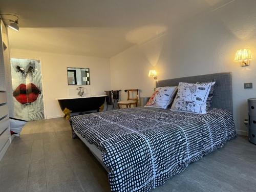 een slaapkamer met een bed met een zwart-witte deken bij Maison de charme avec imprenable vue mer, magnifique piscine et climatisation in Vallauris