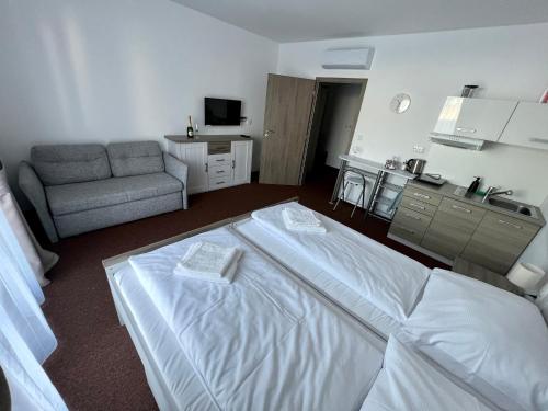 a hotel room with a bed and a couch at BASELINE športový areál & penzión in Banská Bystrica