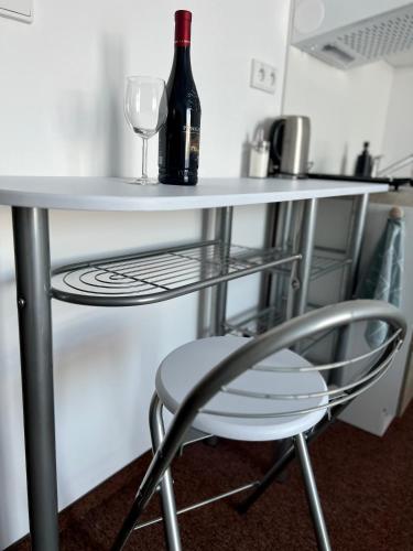 a table with a bottle of wine and a wine glass at BASELINE športový areál & penzión in Banská Bystrica