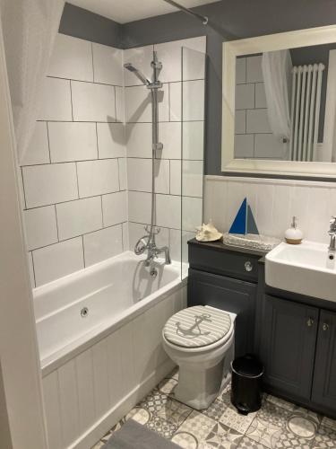 a bathroom with a tub and a toilet and a sink at Old fisherman's Cottage No 4, free parking in Edinburgh