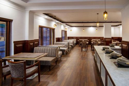 a dining room with tables and chairs and a unintentionermottermottermott at Ashoka Ladakh in Leh