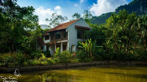 una casa junto a un cuerpo de agua en Tam Coc Garden Resort en Ninh Binh