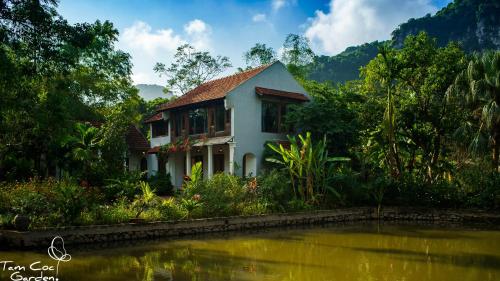 a house next to a body of water at Tam Coc Garden Resort in Ninh Binh