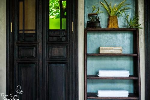 a door with two shelves in front of a house at Tam Coc Garden Resort in Ninh Binh