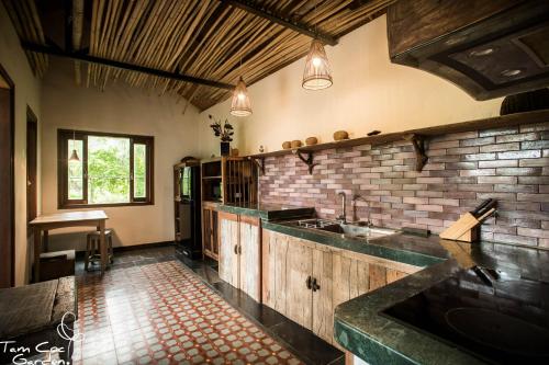 a kitchen with a sink and a brick wall at Tam Coc Garden Resort in Ninh Binh