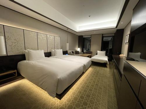 a bedroom with a large white bed in a room at Portom International Hokkaido in Chitose