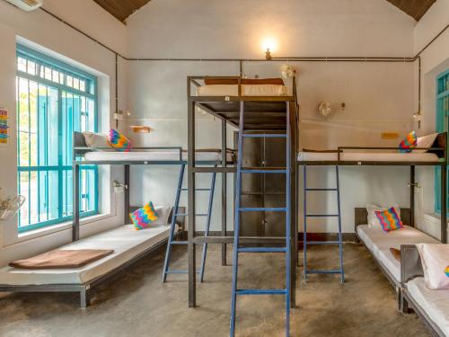 a room with three bunk beds and two windows at goSTOPS Lite Alleppey in Alleppey