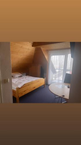 a bedroom with a bed and a desk and a window at Hotel / Gaststätte Jonen‘s Eck in Niederzier
