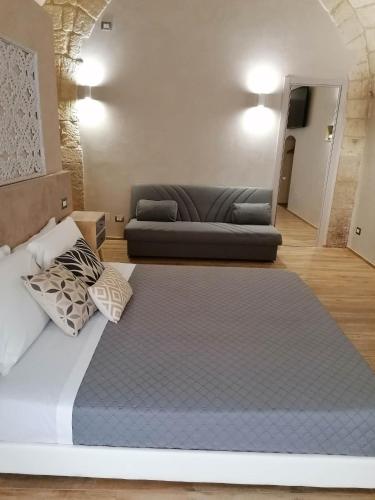 a large bed in a room with a couch at La Dimora del Principe-Piano terra in Trani
