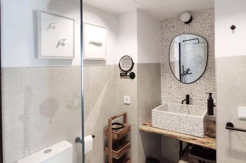 a bathroom with a sink and a mirror at Piso reformado de diseño c/terraza. Playa el Ancla in El Puerto de Santa María