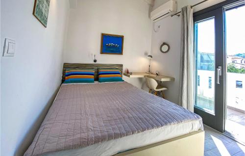 a bedroom with a bed in a room with a window at Beautiful Home In Samos With Outdoor Swimming Pool in Kámpos