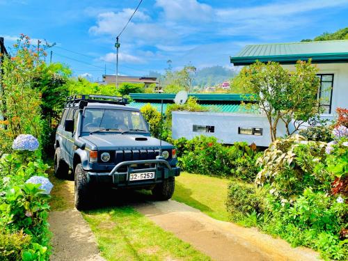 a jeep parked on a dirt road in a garden at Miliya Guest House in Nuwara Eliya