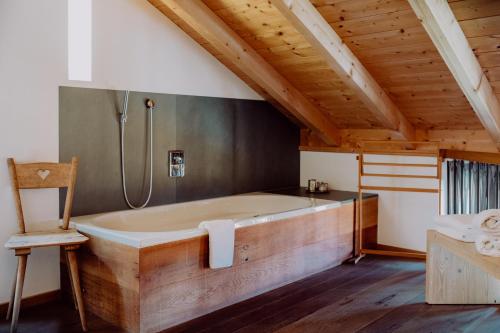 uma grande banheira num quarto com tecto em madeira em Hirzinger - Gasthaus und Hotel em Riedering