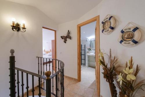 a hallway with a staircase and a clock on the wall at Luminoso chalet in Alcudia
