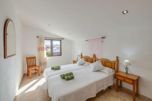 a bedroom with two white beds and a window at Luminoso chalet in Alcudia