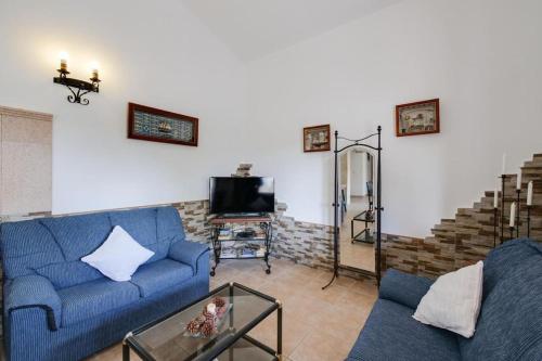 a living room with a blue couch and a tv at Luminoso chalet in Alcudia