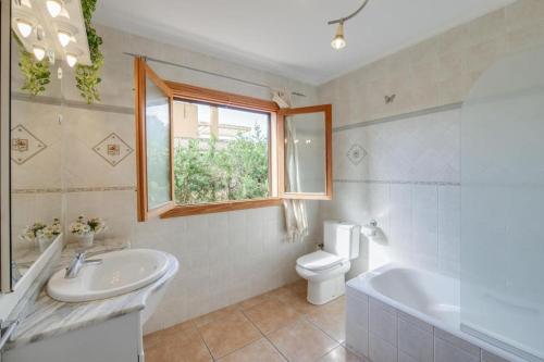 La salle de bains est pourvue d'un lavabo, de toilettes et d'une fenêtre. dans l'établissement Luminoso chalet, à Alcúdia