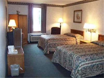 a hotel room with two beds and a television at State Line Inn in Hagerstown