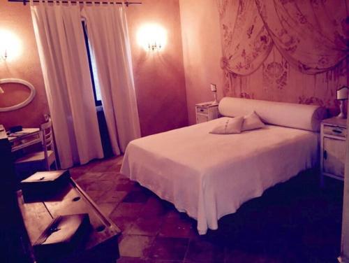 Pontelandolfo的住宿－La Locanda Della Presuntuosa，卧室配有白色的床和镜子
