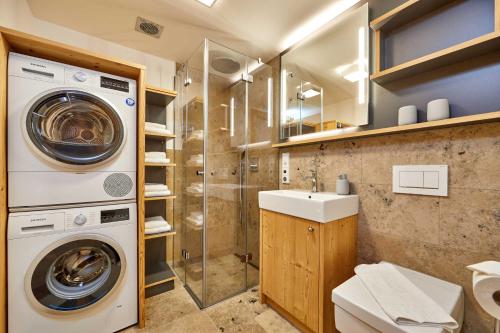 a bathroom with a washing machine and a sink at Parkresidenz in Garmisch-Partenkirchen