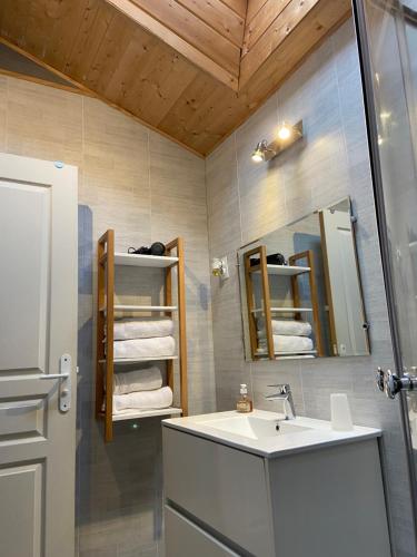 uma casa de banho com lavatório, espelho e toalhas em Le petit moulin em Pouzauges